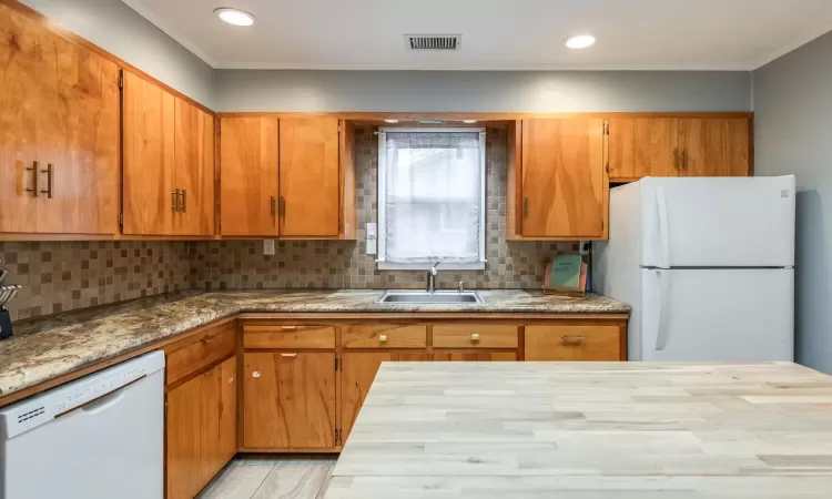 Loads of wood cabinetry, pretty counters & backsplash