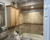 Full bath with combined bath / shower with glass door and visible vents