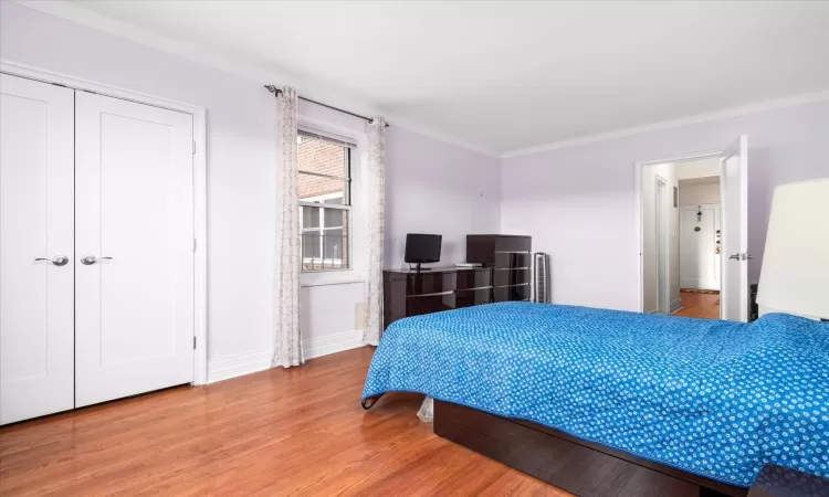 Bedroom with wood finished floors and baseboards