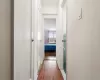 Corridor with dark wood-type flooring and baseboards