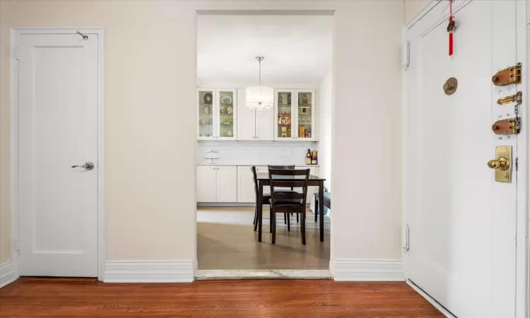 Dining area featuring an inviting chandelier, wood finished floors, and baseboards