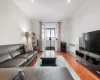 Living room featuring recessed lighting, radiator, baseboards, and wood finished floors