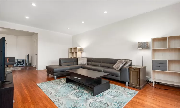 Living area featuring baseboards, wood finished floors, and recessed lighting