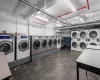 Shared laundry area with a garage, washing machine and clothes dryer, and stacked washer / drying machine