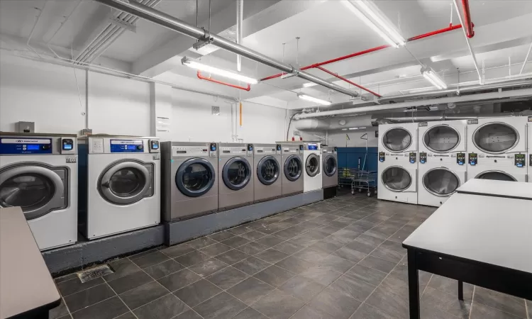 Shared laundry area with a garage, washing machine and clothes dryer, and stacked washer / drying machine