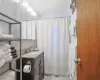 Full bathroom featuring curtained shower, backsplash, toilet, vanity, and tile patterned floors