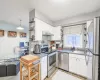 Kitchen with stainless steel appliances, white cabinetry, a sink, and open shelves