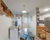 Dining room leading to balcony featuring light wood-style flooring and baseboards