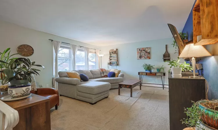 Living room with light carpet and baseboard heating