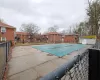 Pool featuring a patio area, fence, and a residential view