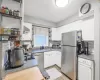 Kitchen featuring stainless steel appliances, white cabinetry, open shelves, and a sink