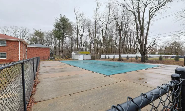 Pool with fence, an outbuilding, and a patio