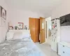 Bedroom featuring a closet, freestanding refrigerator, and light colored carpet