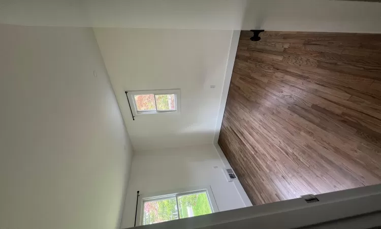 Spare room featuring visible vents, baseboards, and wood finished floors