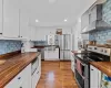 The custom kitchen is accented with butcher block countertops and tile backsplash.