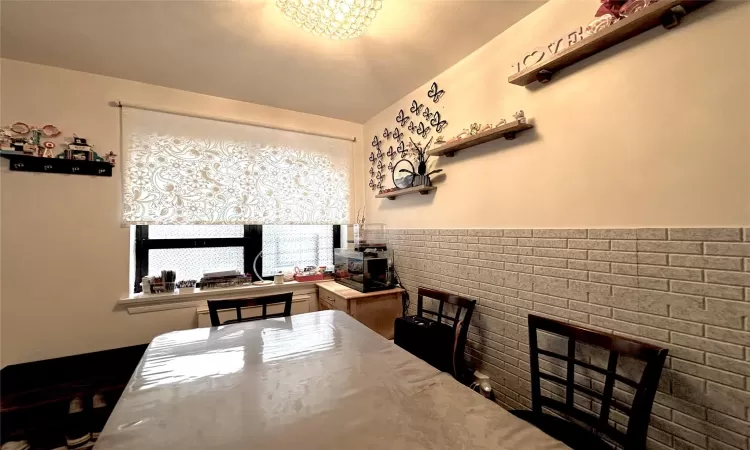 Dining space featuring a chandelier and wainscoting