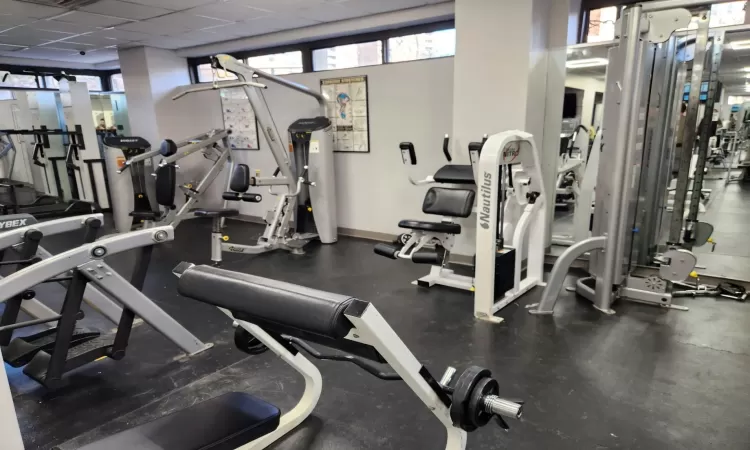 Exercise room with baseboards and a drop ceiling