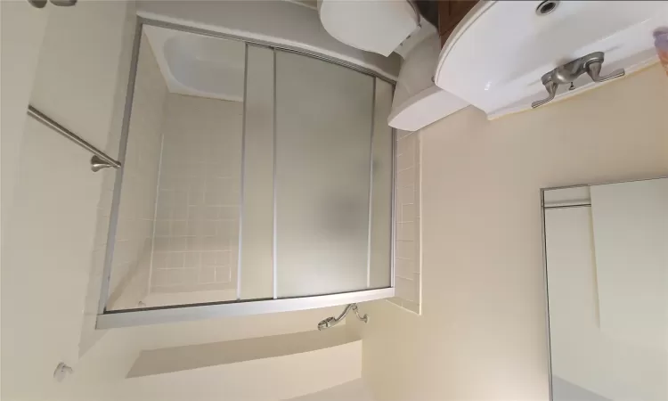 Full bath with shower / bath combination with glass door, vanity, and toilet