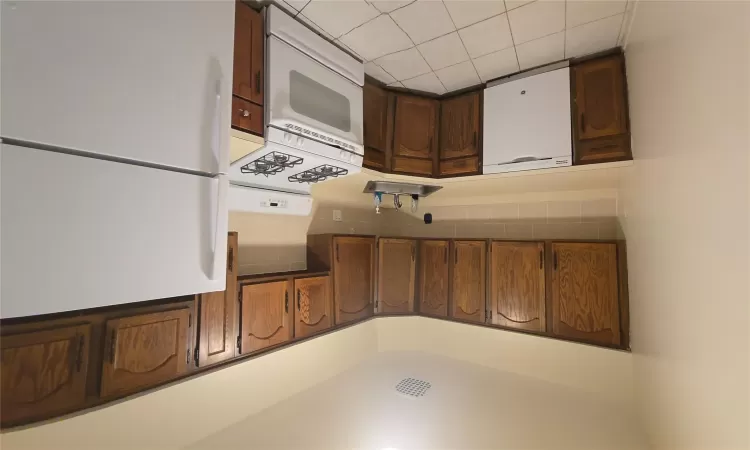 Kitchen with dishwasher, stove, refrigerator, light countertops, and a sink