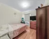 Bedroom with radiator, light wood-type flooring, and crown molding