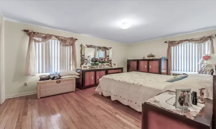 Bedroom featuring hardwood / wood-style flooring and baseboards