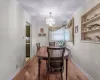 Dining space with light wood finished floors, a notable chandelier, baseboards, and crown molding