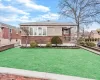 View of front of property with brick siding, stone siding, and a front yard