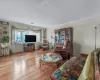 Living room featuring baseboards, crown molding, and light wood finished floors