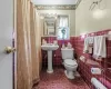 Bathroom with toilet, tile walls, and wainscoting