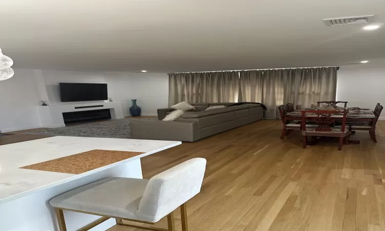 Living area featuring recessed lighting, visible vents, a fireplace, and light wood finished floors