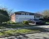 View of front of home with brick siding, a front lawn, and an attached garage