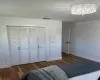 Bedroom featuring baseboards, visible vents, a closet, and wood finished floors