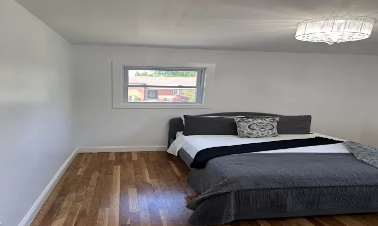 Bedroom with baseboards and wood finished floors