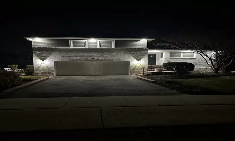 Split level home featuring aphalt driveway and a garage