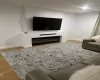 Living room featuring baseboards, wood finished floors, and a glass covered fireplace