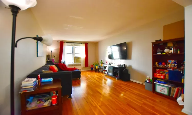 Living area featuring radiator, baseboards, and wood finished floors