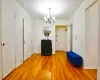 Unfurnished dining area featuring light wood-type flooring, baseboards, and a notable chandelier