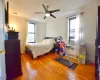 Bedroom with a ceiling fan, radiator, and wood finished floors