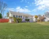 Ranch-style house with a garage, fence, a chimney, and a front lawn