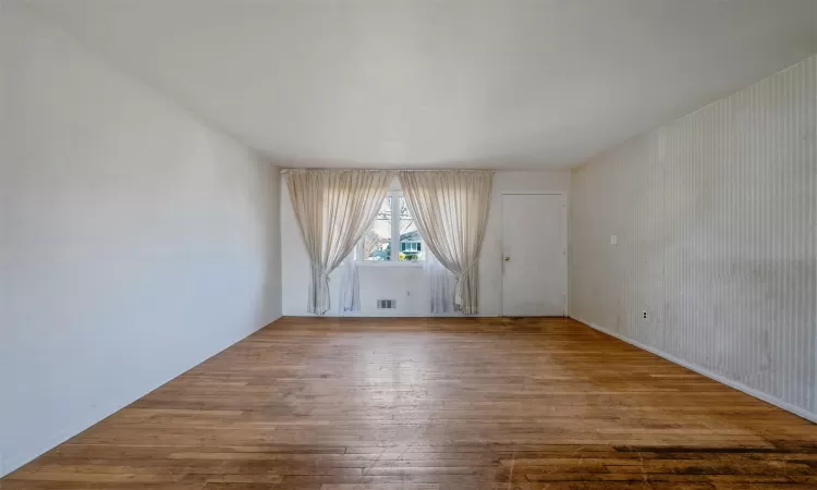 Spare room featuring visible vents and hardwood / wood-style floors