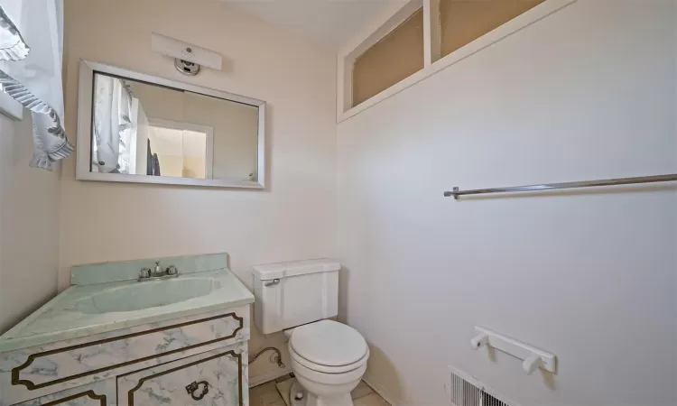 Half bath featuring visible vents, vanity, and toilet