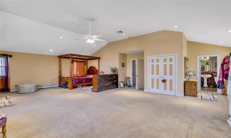 Bedroom featuring light carpet, ceiling fan, a baseboard heating unit, and recessed lighting