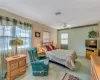 Bedroom with visible vents, a baseboard heating unit, a ceiling fan, light carpet, and baseboards