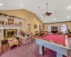 Playroom with visible vents, ceiling fan, carpet flooring, high vaulted ceiling, and a high end fireplace