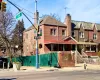 View of front facade featuring fence, brick siding, and a chimney