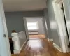 Hallway with hardwood / wood-style floors, radiator, and baseboards