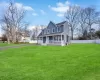 View of front of house with a front lawn, driveway, fence, covered porch, and an attached garage