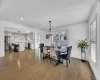 Living room with stairway, wood finished floors, baseboards, recessed lighting, and crown molding