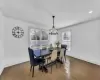 Living room featuring dark wood-style flooring, a warm lit fireplace, and ornamental molding