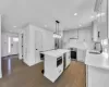 Dining area with a warm lit fireplace, dark wood-type flooring, and ornamental molding